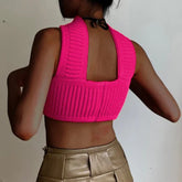 Back view of a woman wearing a hot pink ribbed knit crop top and high-waisted tan pants