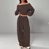 Woman wearing loose brown off-shoulder top and wide-leg pants matching set