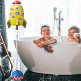 Children in a modern bathtub play with a colorful rocket-shaped water toy, enjoying bath time fun.