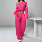 Woman wearing loose hot pink off-shoulder sweatshirt and wide-leg sweatpants set