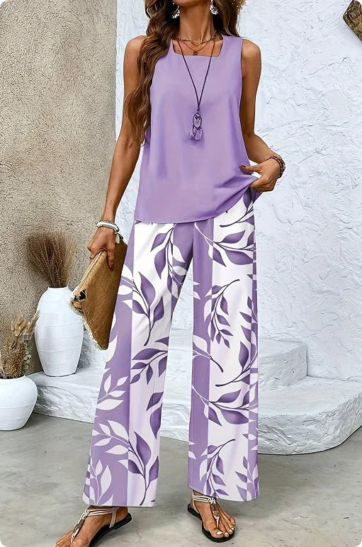 Woman wearing sleeveless lavender top and wide-leg white pants with purple leaf print
