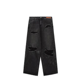 Black wide-leg distressed jeans with ripped details and relaxed fit, streetwear style.