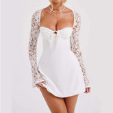 White mini dress with lace long sleeves, fitted bodice, tie front, and flared hem