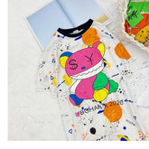 White oversized t-shirt with colorful cartoon bear graphic, splatter print, and playful streetwear style.