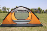 Orange and gray dome tent with mesh panels pitched on grass in sunny outdoor setting