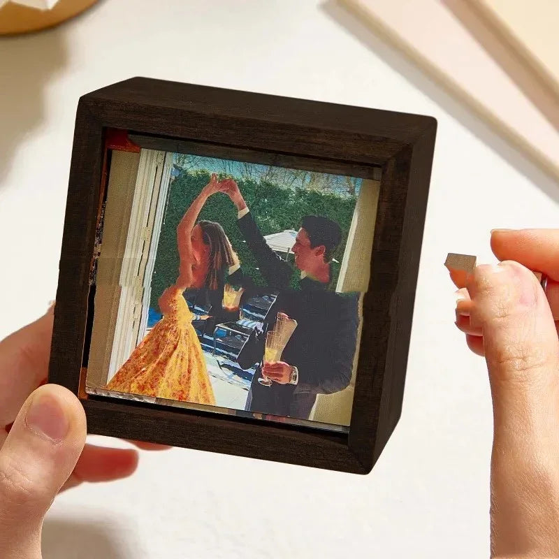 Woman in a yellow floral dress and man in a black suit dancing, displayed in wooden frame