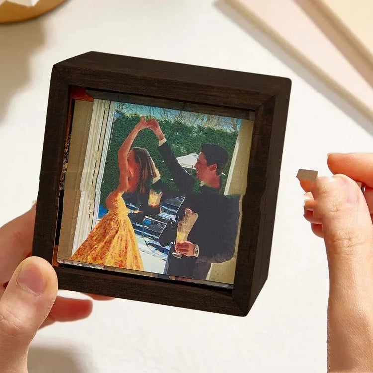 Woman in a yellow floral dress and man in a black suit dancing, displayed in wooden frame