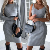 Woman in fitted gray ribbed knit dress with long sleeves and sleeveless options, accessorized with black bag.