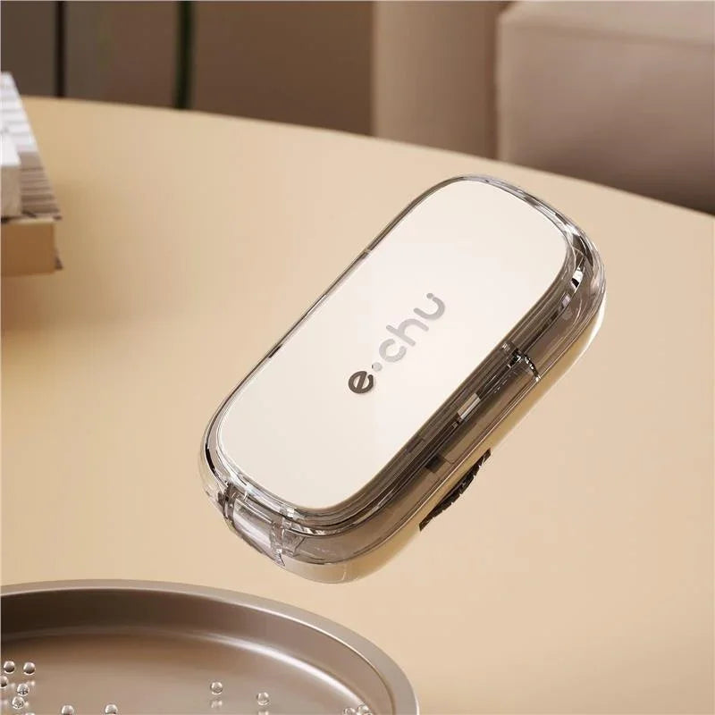 Beige rectangular tech gadget with a transparent edge and metallic finish on a minimalist table