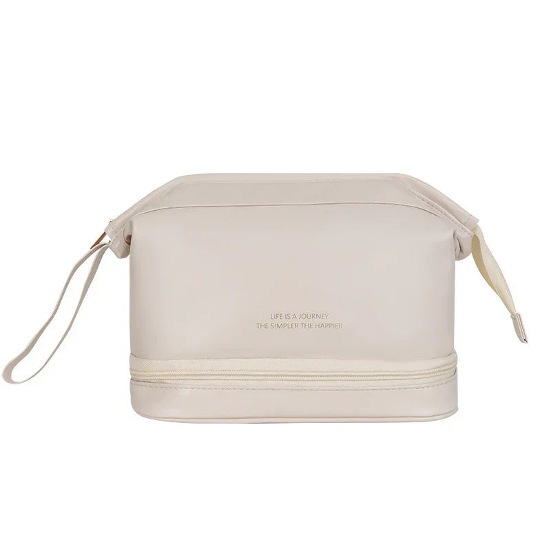 Beige faux leather travel pouch with wrist strap and zippered bottom compartment, minimalist style