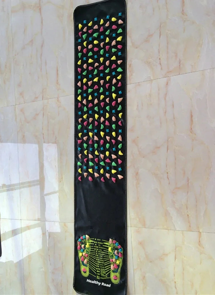 Black acupressure massage mat with multicolored raised stones for foot reflexology