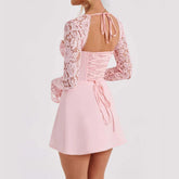 Light pink lace long sleeve mini dress with fitted bodice and corset tie-back detail
