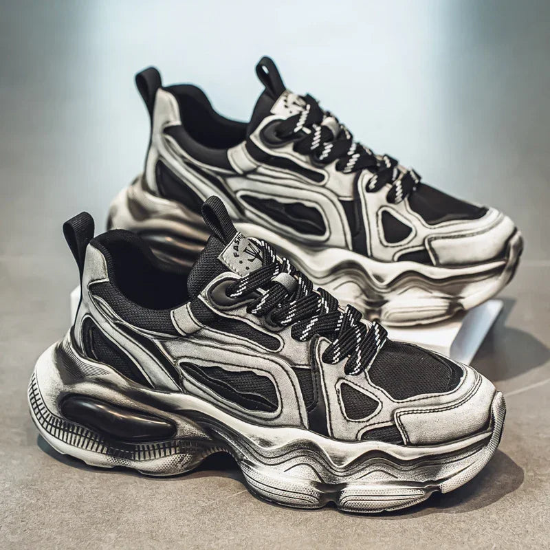 Chunky black and grey futuristic sneakers with mesh panels and thick sculpted soles