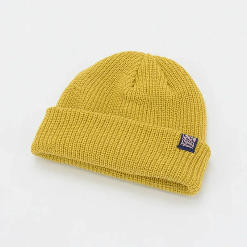 Mustard yellow ribbed knit beanie with folded cuff and relaxed fit.