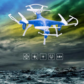 Blue and white plastic quadcopter drone flying over stormy ocean with protective propeller guards.