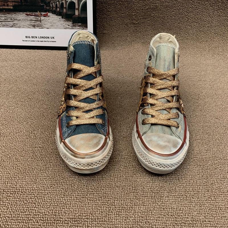 Mismatched denim high-top sneakers with gold laces and vintage wash on carpet