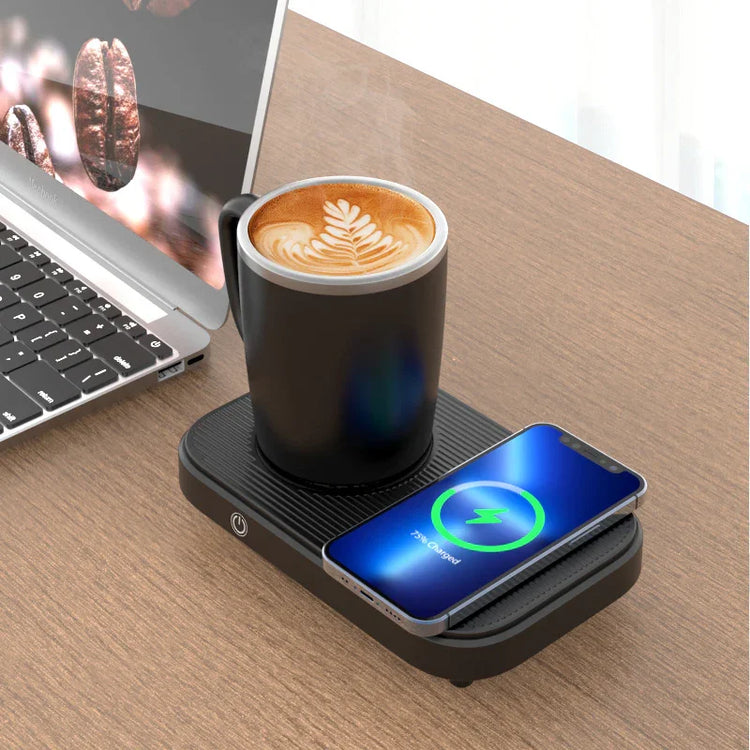 Black ceramic mug with latte art on a mug warmer, wireless phone charger, and laptop on wooden desk