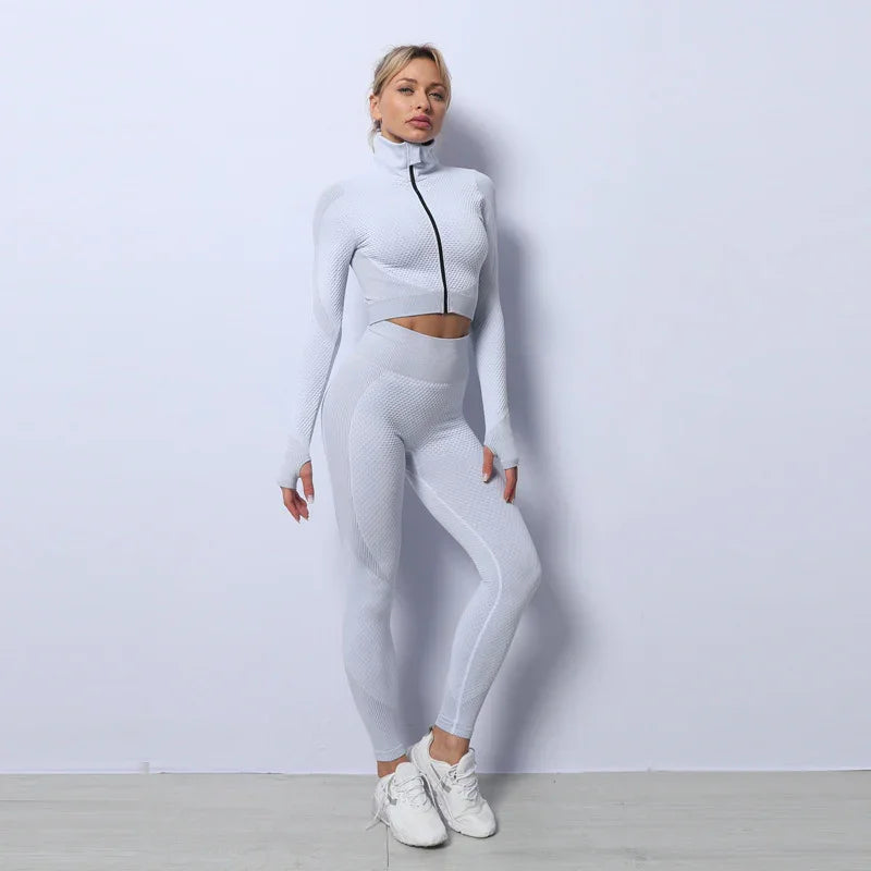 Woman in textured white fitted athleisure set with high-waist leggings and zip-up crop top