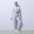 Woman in textured white fitted athleisure set with high-waist leggings and zip-up crop top