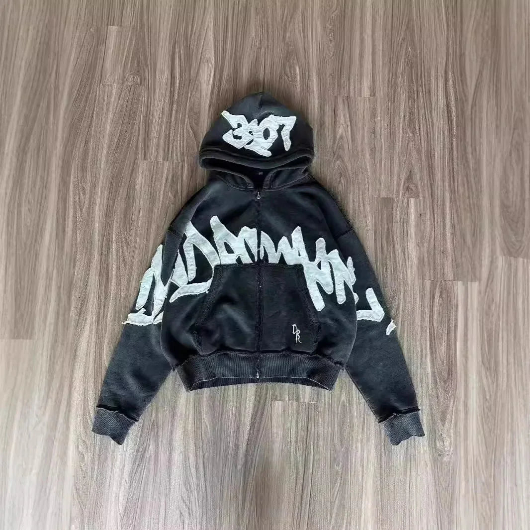 Black oversized zip-up hoodie with bold white graffiti print and relaxed fit, cotton blend