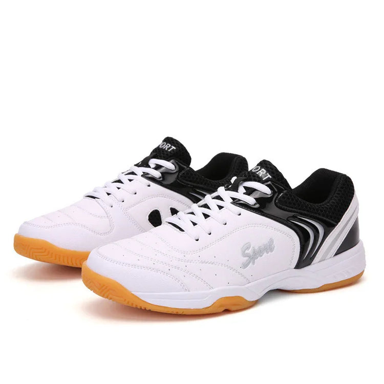 White and black low-top sneakers with gum sole, mesh accents, and sporty laced design.