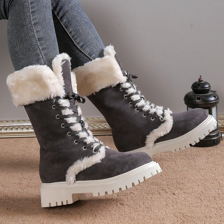 Gray suede winter boots with white faux fur lining and chunky lug soles, worn with jeans.