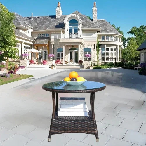 Outdoor glass-top wicker patio table with fruit bowl, modern luxury mansion background