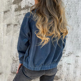 Woman wearing loose-fit blue corduroy jacket and black jeans, casual streetwear style