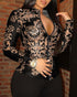 Woman wearing a fitted black and gold baroque print zip-up jacket with high collar