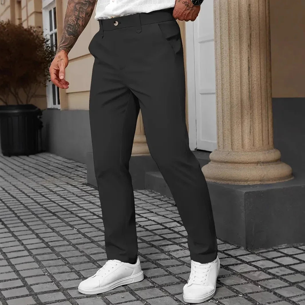 Men’s slim fit black dress pants with side pockets, paired with white sneakers, outdoor setting