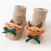 Beige ribbed socks with soft plush reindeer decorations and green bows, cozy winter style.