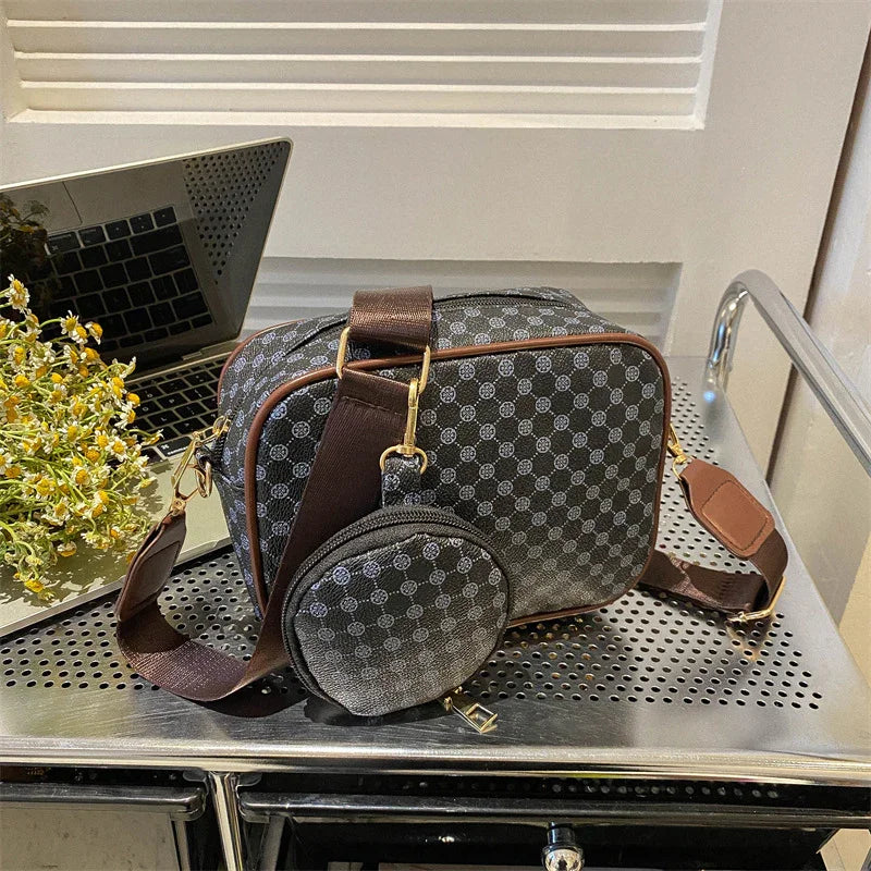 Black and gray crossbody bag with geometric pattern, brown strap, and matching pouch