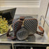 Black and gray crossbody bag with geometric pattern, brown strap, and matching pouch