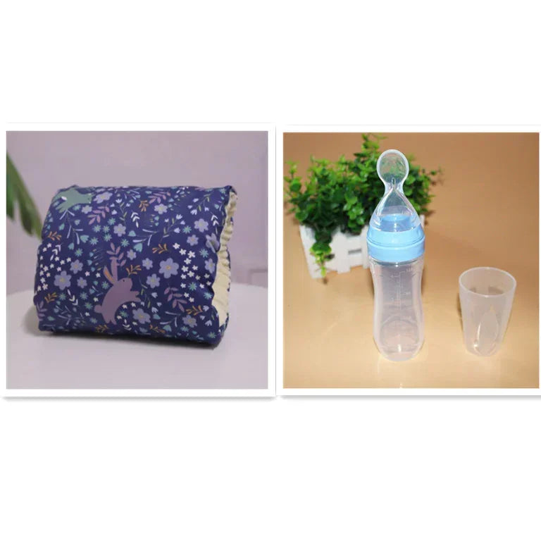 Blue floral-patterned baby pillow and clear baby bottle with blue cap and spoon, soft fabric