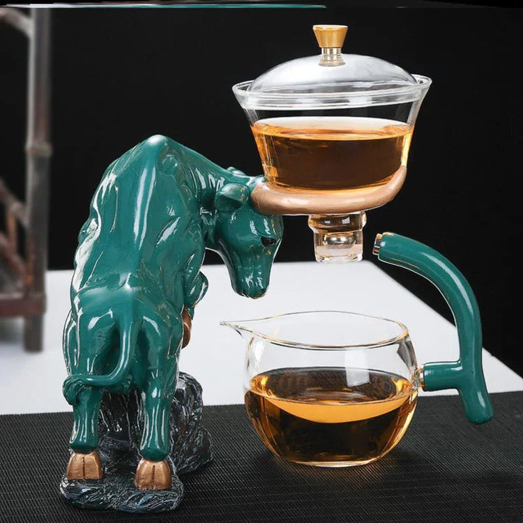 Green and gold bull-shaped ceramic tea set with glass teapot and cup, modern tabletop style