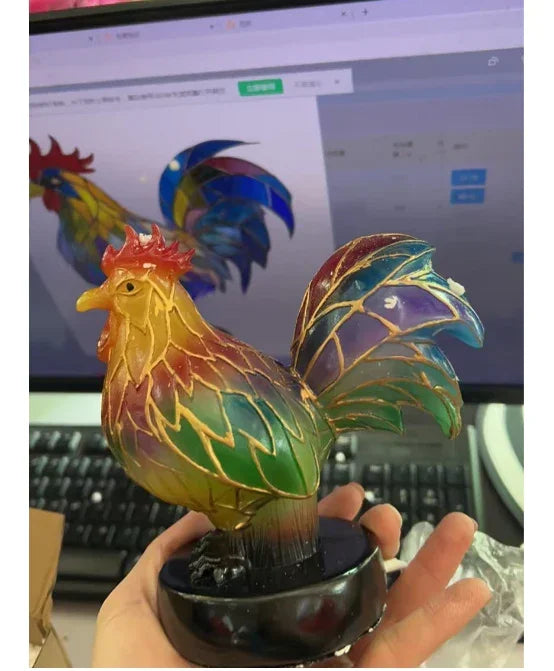 Hand holding a multicolor rooster figurine made of translucent, stained-glass style material.