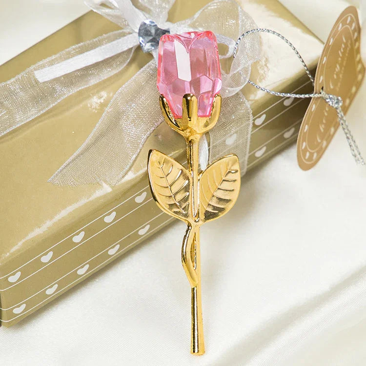 Gold metal rose with pink crystal flower, elegant decorative accessory on gift box