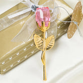 Gold metal rose with pink crystal flower, elegant decorative accessory on gift box