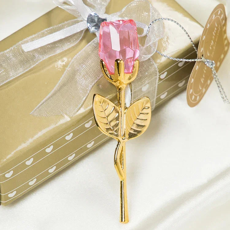 Gold metal rose with pink crystal flower, elegant decorative accessory on gift box