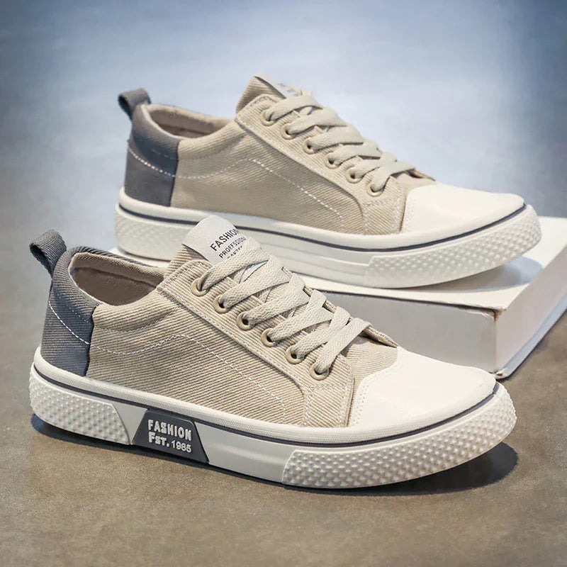 Beige canvas low-top sneakers with white rubber soles and gray accents, casual streetwear style