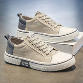 Beige canvas low-top sneakers with white rubber soles and gray accents, casual streetwear style