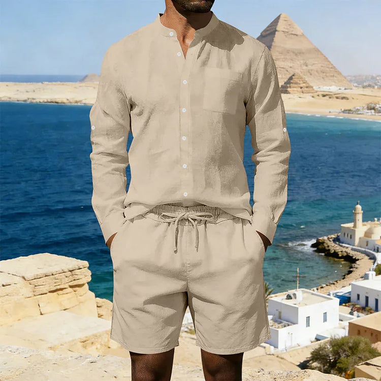 Man wearing a beige linen button-up shirt and drawstring shorts set, relaxed fit, coastal background