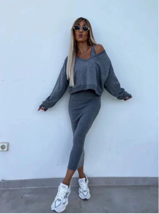 Woman wearing grey knit two-piece set with off-shoulder cropped sweater and fitted midi skirt