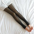 Sheer black tights with a slim fit, worn with a white shirt, lying on a bed.