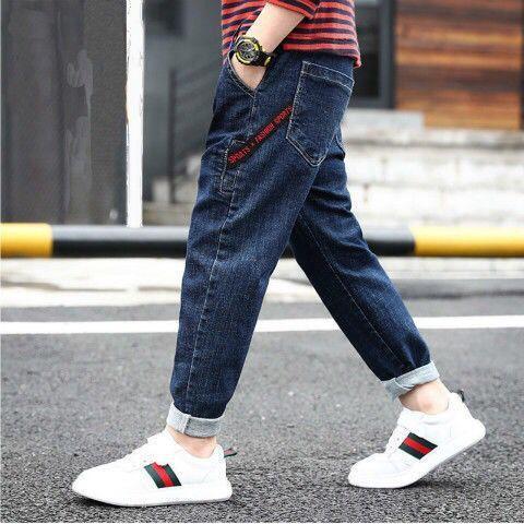 Casual dark blue straight-leg jeans with rolled cuffs, paired with white low-top sneakers