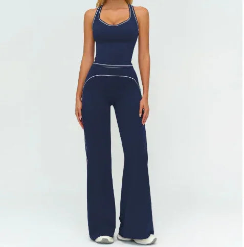Woman wearing navy blue fitted tank top and wide-leg pants with white piping, sporty streetwear style