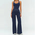 Woman wearing navy blue fitted tank top and wide-leg pants with white piping, sporty streetwear style