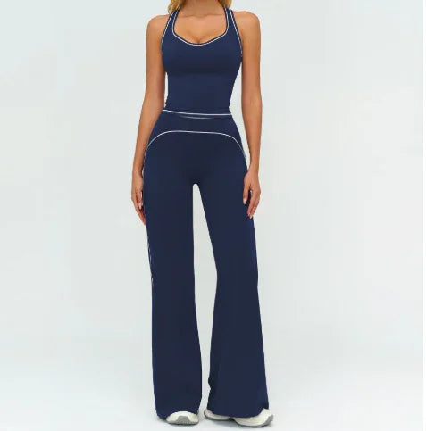 Woman wearing navy blue fitted tank top and wide-leg pants with white piping, sporty streetwear style