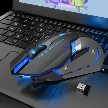 Futuristic black and blue wireless gaming mouse with LED lights on a laptop keyboard