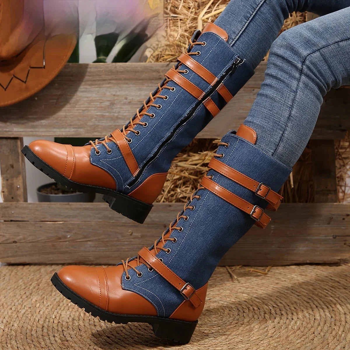 Blue denim knee-high boots with brown faux leather straps and laces, slim fit style